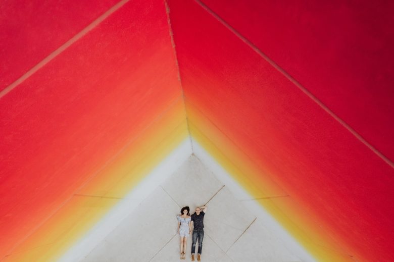 Leslie and Gustavo lie together beneath the vivid red and orange geometry of Tau Ceti in downtown Austin.